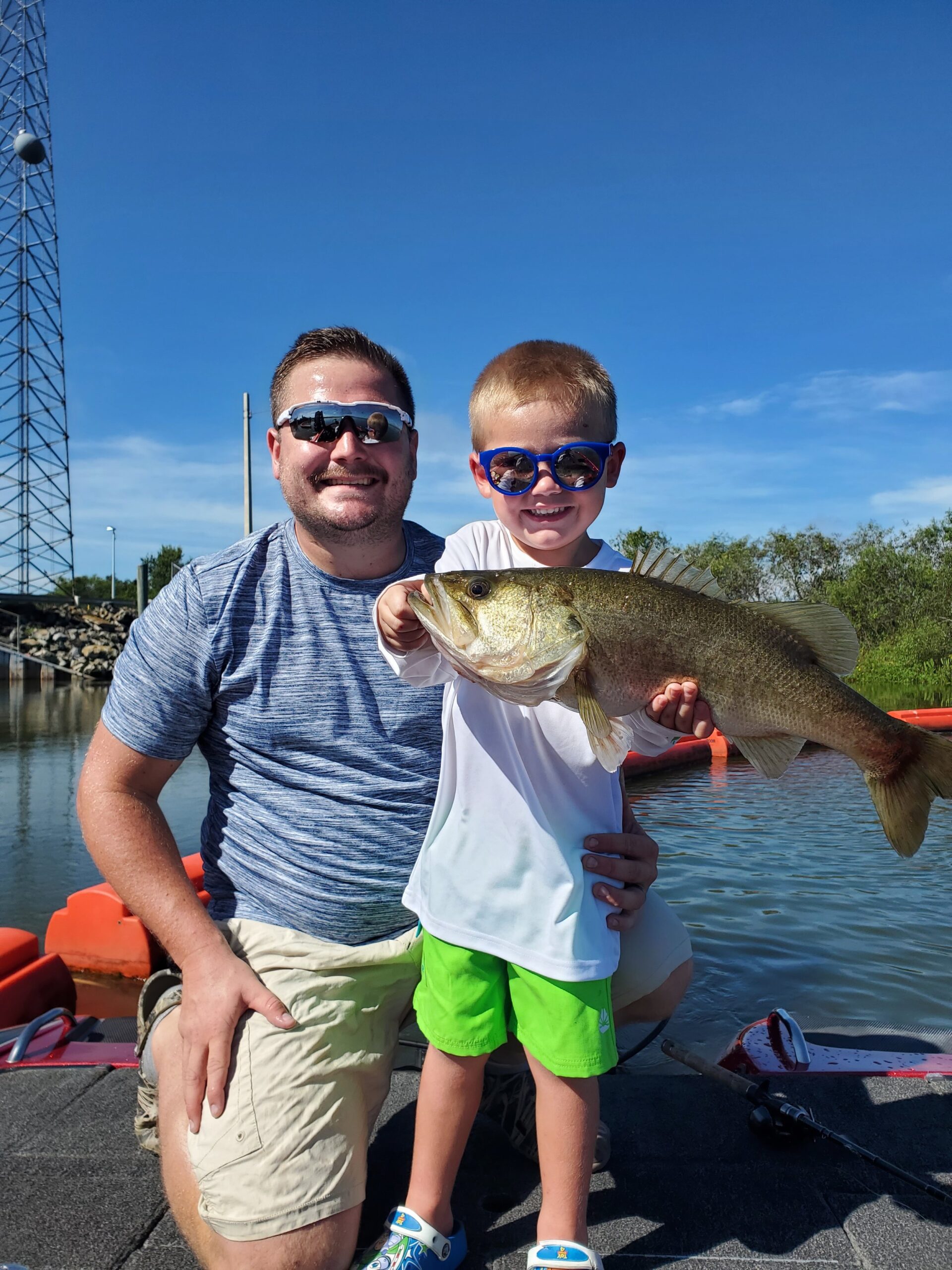 Father Son Holding A Huge Bass